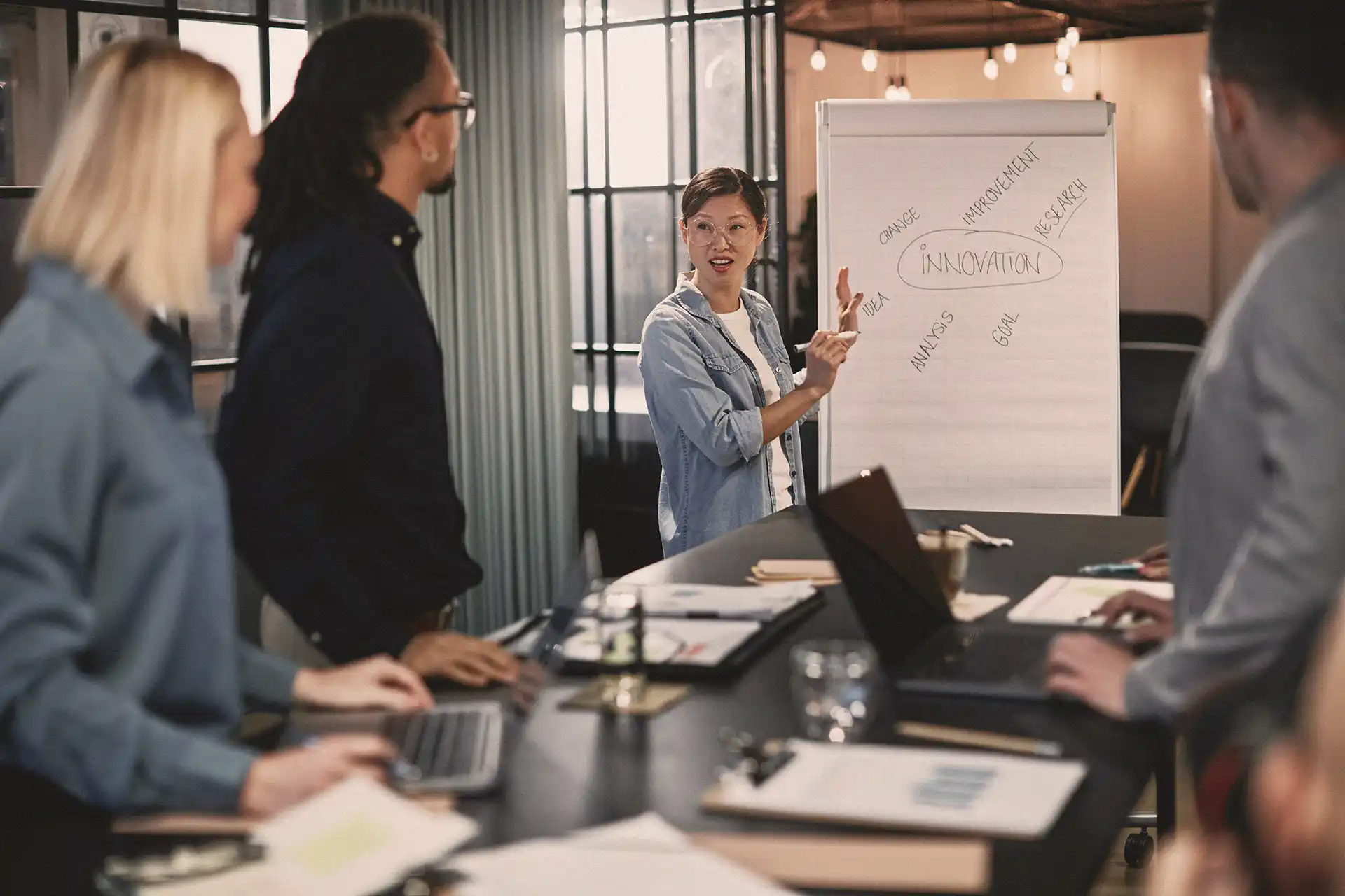 A group of young professionals analyzing a business development plan written on a white board.